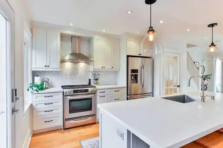 Bright modern kitchen with white cabinetry and island, spotless and professionally cleaned by Heavenly Touch Maids